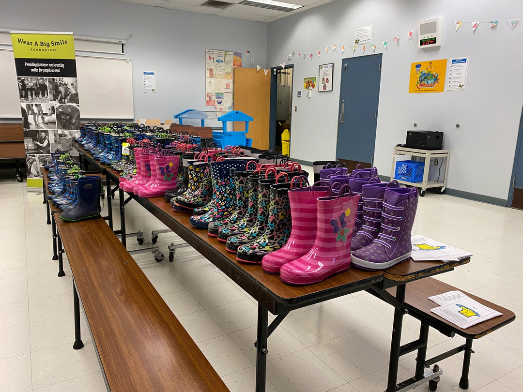 Western Chief Kids Rain Boots on a table in a classroom ready to donate to children.